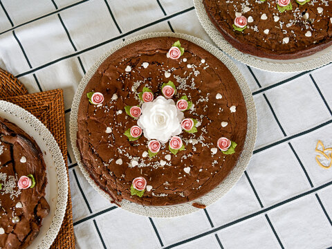 G&acirc;teau fondant au chocolat d&eacute;cor&eacute; de fleurs en sucre roses et perles blanches vu du dessus