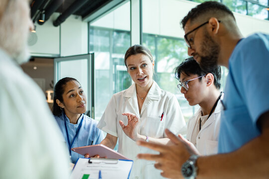 Doctors and nurses discussing patient care in modern hospital