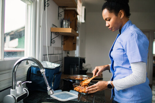 Healthcare worker packing lunch in home kitchen