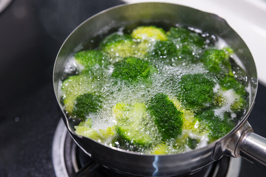 Fresh green broccoli florets boiling in hot water