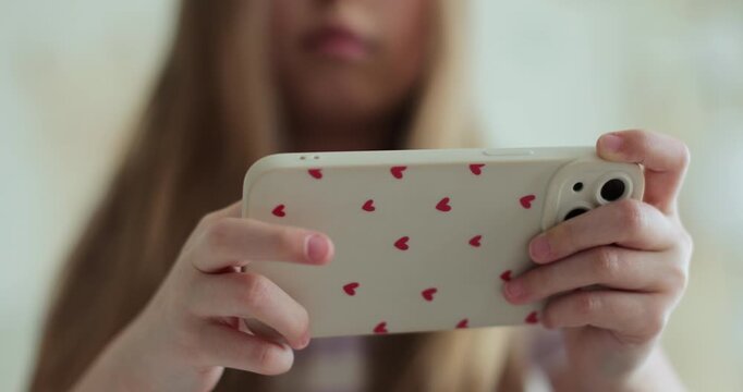 The kid is playing virtual games or watching cartoons on her smartphone. The problem of addiction to gadgets.