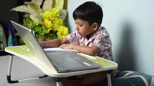 Young Indian boy studying on laptop at home, online education concept, Delhi, India