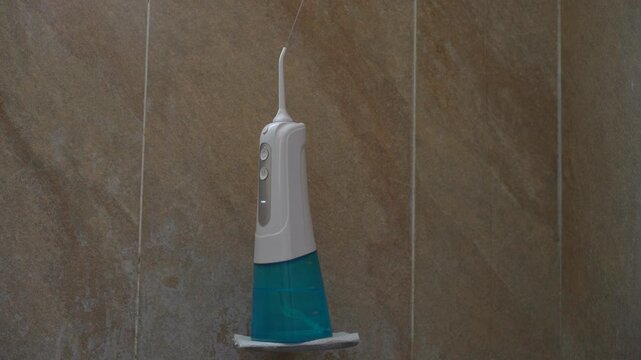 Cordless dental water flosser in a shower. Uncompressed 24 bit high quality sound. Oral care technology and dental health concept
