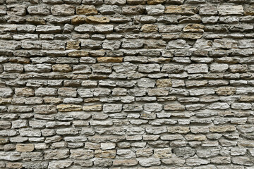 Fototapeta premium Full frame texture of old rustic stone wall built from rough natural limestone blocks