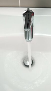 Top view of man turns off the faucet in the bathroom
