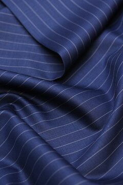 Luxury navy blue pinstripe suit fabric. Ultra-premium bespoke pure wool textile for high-end tailoring. Elegant white stripes with 1.1 cm spacing. Exquisite texture, the absolute finest quality.