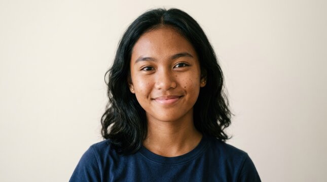 A young girl with long black hair smiling.