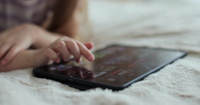 Close-up finger scrolling social media. Girl browsing digital tablet computer. The problem of addiction to gadgets.