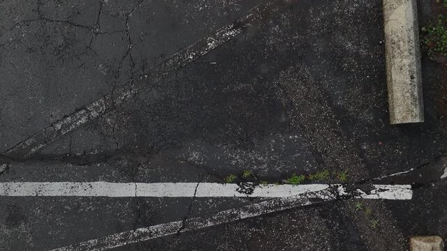 Detailed grunge background of the asphalt between two parking spots