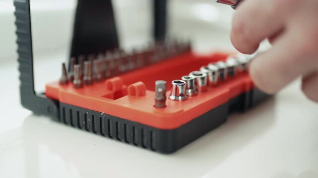 Close-up of a handyman in a jumpsuit assembling a multi-bit screwdriver, professional DIY project, 4K footage