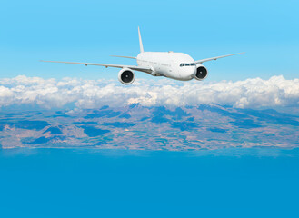 Naklejka premium A passenger plane takes off over the coastal city and mountains.