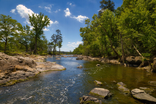 A beautiful river landscape in the forest with rocks and bubbles flowing downstream on the Lower Haw Hiver in Pittsboro, North Carolina. Eastern United States of America
