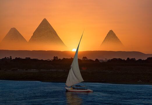 Giza pyramid Complex by the Nile at amazing sunset - Fishermen casting their fishing nets on a boat in Nile river at amazing sunset - Egypt