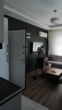 Traveler checking out from furnished apartment with luggage, leaving temporary accommodation after short stay, travel lifestyle and digital nomad departure concept. Vertical