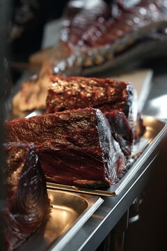 Fresh raw tuna steaks on metal tray, red seafood cuts in market display, close-up food and culinary photography