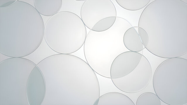 A close-up photo shows numerous transparent glass or plastic discs of varying sizes overlapping each other, creating a visually striking pattern of circles and ovals in the image.