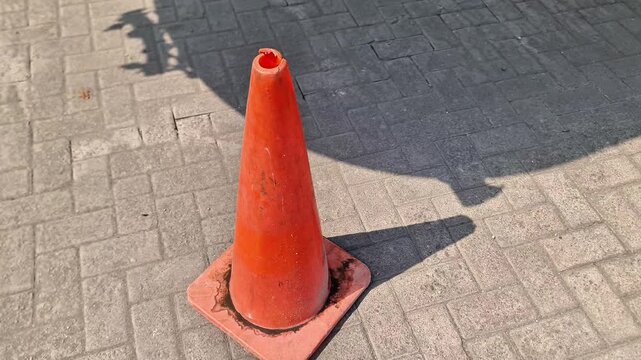 Weathered Bright Orange Traffic Cone on Paved Parking Lot for Safety and Traffic Control