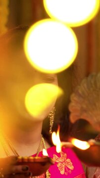 Couple Lighting Brass Oil Samai on Diwali , Indian Young Man and Woman in Traditional Kurta and Saree Smiling While Lighting Decorative Festival Lamp at Night Inside Cozy Ethnic Home Setting