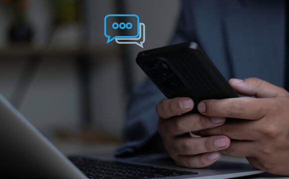 Digital Communication and Customer Support Chat. Close up of hands using smartphone with chat bubble icons for online messaging, social media conversation, and digital support.
