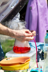 Obraz premium Science show for kids, exciting chemical experiments with dry ice smoke and colorful liquids
