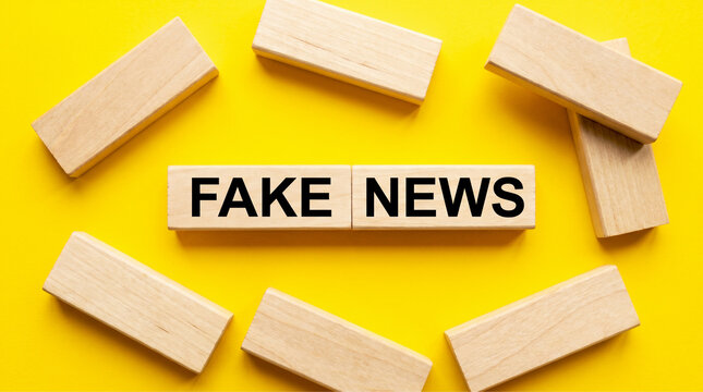 Fake News Blocks: Conceptual image representing the pervasive spread of fake news, with wooden blocks spelling out FAKE NEWS surrounded by scattered blocks on a vibrant yellow background.