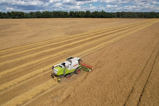 Prostejov,Czech Republic-July 16 2025: Claas Lexion 550 combine harvester working in wheat field during harvest captured in aerial panorama