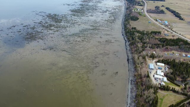 Drone footage of the St. Lawrence River coastline at low tide near Reford Gardens and La Villa Estevan Lodge in Gaspesie, Quebec, Canada.