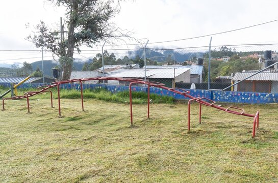 Red Monkey Bars in Outdoor Playground with Mountain Background