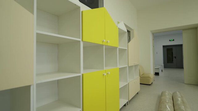 Vibrant storage unit features multiple shelves and unique geometric design. Artistic furniture piece adds playful energy to interior