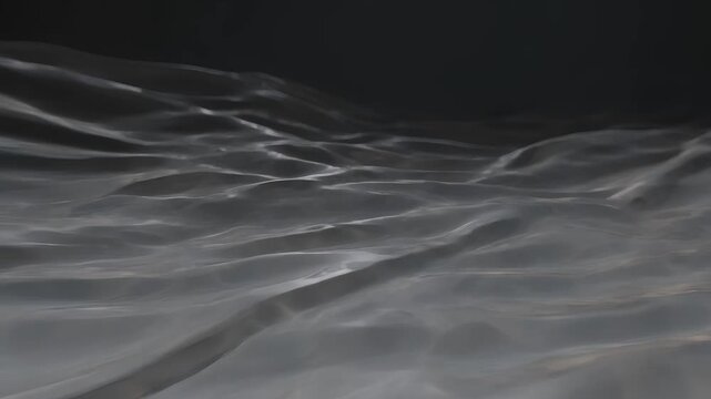 Rippling transparent plastic sheet on dark background wavy motion abstract texture