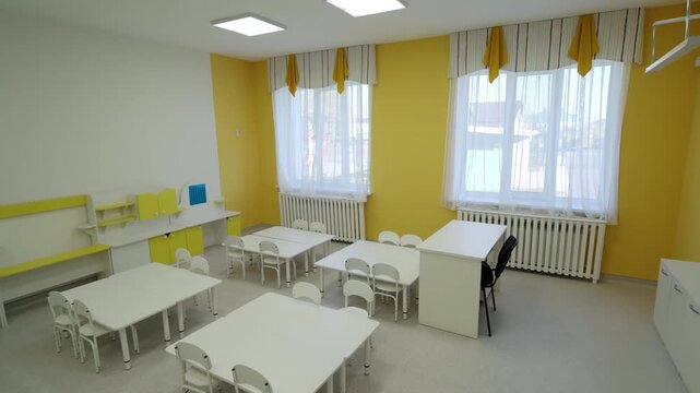 Cozy classroom features small wooden desks and large dark chalkboard. Learning space provides comfortable environment for young students