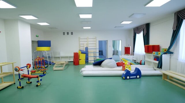 Spacious kindergarten gym organized with child-sized weight benches. Vibrant primary colors create cheerful and energetic environment