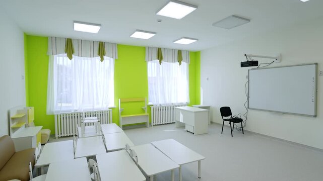 Green accent wall frames large bright windows with soft curtains. Minimalist interior design offers comfortable space for students