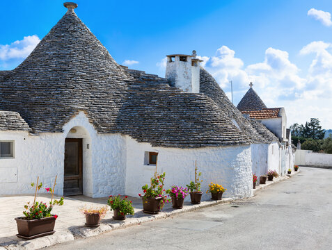 Small winding street with typical Trulli houses in Alberobello, Apulia, Italy
