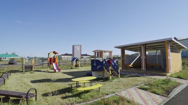 Ship-shaped play structure stands in center of park near primary school. Colorful equipment sparks imagination during outdoor recess time