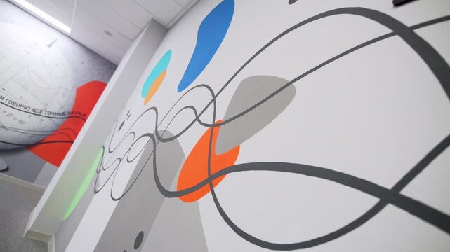 Abstract mural with contrasting circles and swirls decorates wall. Colorful artistic patterns create energetic atmosphere in outdoor space