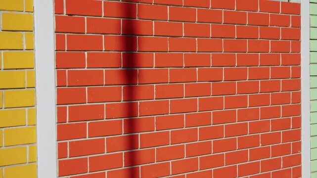 Colorful masonry shows modern building facade details closeup. Simple architecture and clear sky define peaceful suburban setting