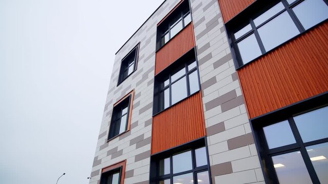 Building facade features brick patterns with contrasting panels. Sharp shadows and straight lines emphasize modern architectural style
