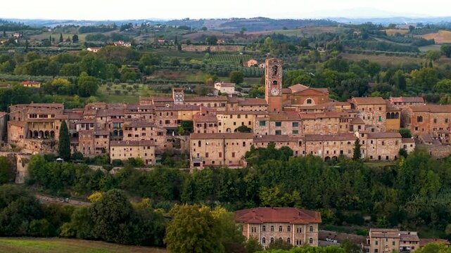 Cinematic Colle di Val d Elsa Tuscany. Aerial 4K drone sideways tracking shot of medieval hilltop borgo at sunset. Golden hour Tuscan rolling hills background scenery. Historic valley travel landscape