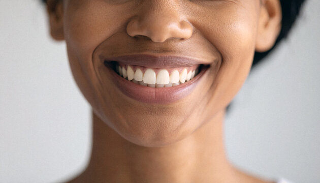 Close up of a black woman smiling on neutral gray background