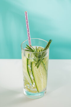 Minimal fresh cucumber drink with herbs on blue background
