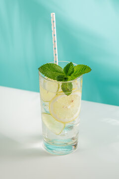 Fresh lemon and mint non alcoholic drink with ice on blue background