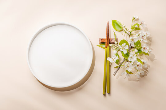 Empty white plate with chopsticks and blue bowl
