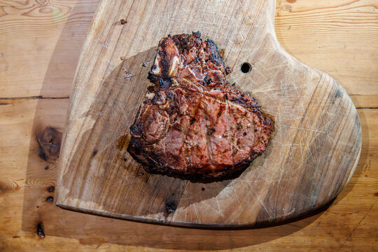 Cooked T-bone steak on wooden board