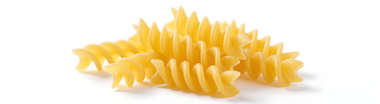 cluster tightly wound uncooked fusilli pasta spirals bright sunshine yellow hue centered crisp white studio backdrop soft