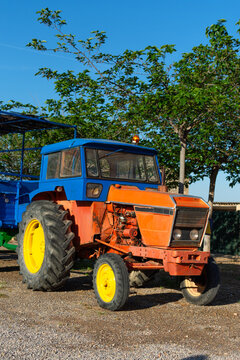 vertical view of old tractor with trailer in field