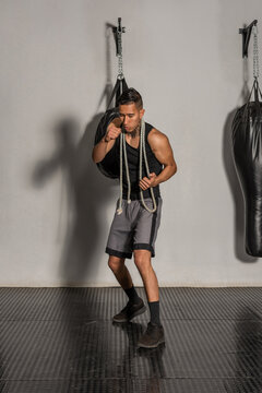 Young Hispanic boxer warming up with shadow boxing in gym