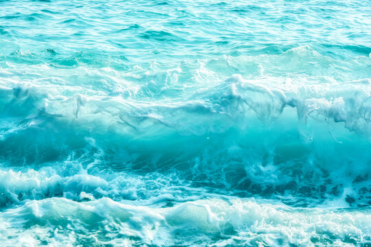 Turquoise blue ocean surface with waves and white foam, abstract sea water texture background, tropical marine nature