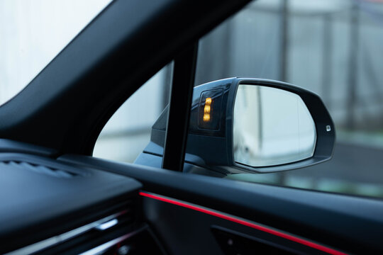 Blind zone monitoring sensor on the side mirror of a modern electric car. System blind spots of the car. Detail of side keeping assist system switch button