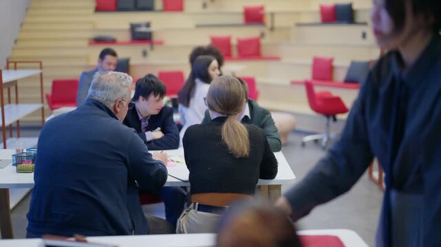 Coworkers engage in a productive meeting, discussing important business strategies. Professionals collaborate around a table, fostering an inclusive work environment.